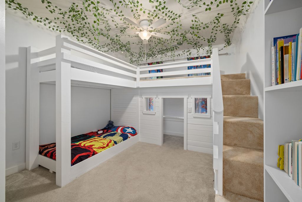 A captivating children's bedroom featuring a white lofted bunk bed and leafy ceiling decor.