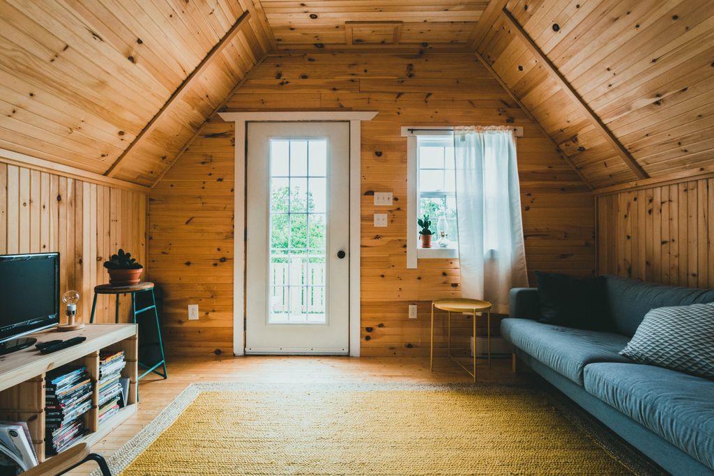 Warm and inviting wooden cabin interior featuring modern furniture and natural light.